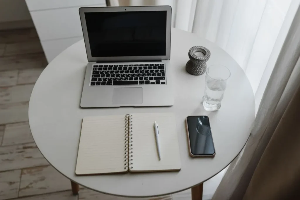 Clean workspace with laptop, notebook and phone placed away